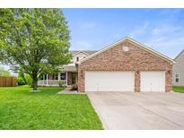 Charming two-story home with a well-manicured lawn and attached two-car garage at 6026 Pennyworth Cir, Indianapolis, IN 46203