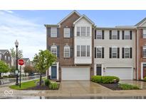 Charming brick townhome featuring a two-car garage and a neatly landscaped front yard at 6916 Havenmoor Pl, Indianapolis, IN 46250