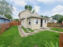 Charming tan two-story home with a small front yard and stone walkway to the front door at 704 E Perry St, Indianapolis, IN 46227