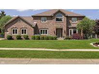 Charming brick home featuring manicured lawn and mature landscaping at 7430 Franklin Parke Woods, Indianapolis, IN 46259