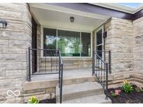 Inviting front porch with stone details and decorative railing welcomes you home at 1108 N Ritter Ave, Indianapolis, IN 46219