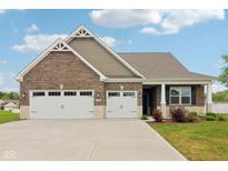 Charming brick home featuring a large three car garage and well-manicured lawn at 1270 Shaw Ln, Shelbyville, IN 46176