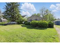 Charming single-story home with a spacious front lawn and mature landscaping at 1515 S Emerson Ave, Indianapolis, IN 46203