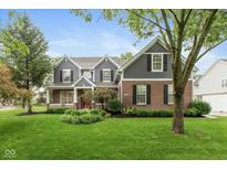 Charming two-story home with brick and gray siding, complemented by a well-maintained lawn and mature trees at 17002 Folly Brook Rd, Noblesville, IN 46060
