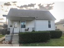Charming single-story home featuring a covered porch and well-maintained landscaping at 21 Reo St, Columbus, IN 47201