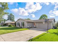 Charming ranch home with a well-manicured lawn, attached garage, and basketball hoop at 2810 Bittersweet Blvd, Columbus, IN 47203