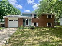 Charming brick home features attached garage and manicured front lawn, creating a welcoming curb appeal at 3023 Fairlawn Dr, Columbus, IN 47203