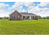 Charming brick home with a well-manicured lawn and inviting front porch at 3319 E 700 N, Whiteland, IN 46184