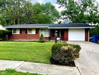 Charming red brick home with a well-maintained lawn and attached garage in a suburban setting at 3633 Tiffany Dr, Indianapolis, IN 46226