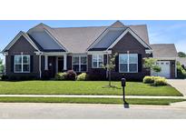 Beautiful brick home with a manicured lawn, complemented by lush landscaping and a welcoming entrance at 3691 Talmine Ln, Bargersville, IN 46106