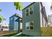 Side view of modern homes with wood plank exteriors, windows, and lawn with wooden fence at 39 N Walcott St, Indianapolis, IN 46201
