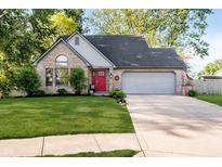 Charming brick home features a bright red front door and well-manicured lawn, and an attached two-car garage at 410 Wood Hollow Ct, Westfield, IN 46074