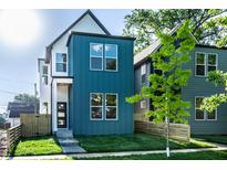 Modern home featuring a vibrant blue exterior, complemented by a well-manicured lawn and thoughtful landscaping at 43 N Walcott St, Indianapolis, IN 46201