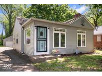 Charming single-story home with light gray siding, a neatly manicured lawn, and a secure screen door at 4809 Allisonville Rd, Indianapolis, IN 46205