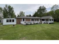 Charming brick home featuring a spacious front yard and white railed porch, perfect for relaxing outdoors at 5725 W 200 N, Lebanon, IN 46052