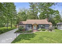Charming home featuring a well-manicured lawn, beautiful landscaping, and a cozy front porch at 6110 Orinoco Ave, Indianapolis, IN 46227