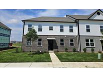 Charming two-story home features brick and white siding, complemented by a well-manicured lawn and inviting walkway at 6150 Cascades Dr, Whitestown, IN 46075