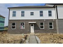 A view of the exterior of the house featuring a brick and white siding and a gray concrete walkway at 6150 Cascades Dr, Whitestown, IN 46075