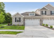 New townhome features a two-car garage, brick facade, and manicured lawn at 6465 Wasco Dr, Whitestown, IN 46075