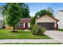 Cozy one-story home with a red roof, a two-car garage, and a well-maintained front yard at 6715 Wandering Way, Indianapolis, IN 46241