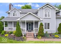 Charming two-story home with gray siding, covered porch, and well-manicured landscaping at 7056 E 171St St, Noblesville, IN 46062
