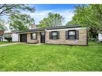 Charming single-story home featuring a stone facade, attached garage, and a well-maintained lawn at 7625 E 35Th St, Indianapolis, IN 46226