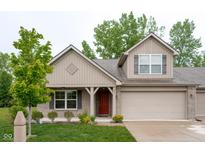 Charming exterior elevation of home featuring brick accents, covered porch, attached garage and manicured front lawn at 808 Heartland Ln, Brownsburg, IN 46112