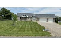 Attractive brick home with a two-car garage, paved driveway, and a meticulously striped lawn at 951 N Maiellen Dr, Greenfield, IN 46140