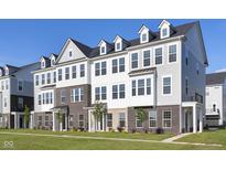 Modern townhome showcases a brick and siding exterior, dormer windows, and lush green lawn at 14515 Hanford Ln, Carmel, IN 46074