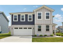 Beautiful two-story home featuring a two-car garage, brick accents, and eye-catching blue and gray siding at 1807 Orchard Dr, Fortville, IN 46040