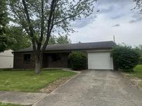 Charming single-story brick home featuring a well-maintained lawn and an attached one car garage at 3055 Pawnee Dr, Indianapolis, IN 46235
