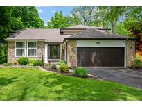 Charming home featuring stone accents, a well-maintained lawn, and a two-car garage at 3230 Amherst St, Indianapolis, IN 46268