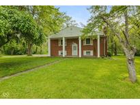 Charming brick home featuring a spacious lawn and classic architectural details at 502 S Harrison St, Alexandria, IN 46001