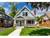 Charming two-story home with a well-manicured lawn and inviting front porch at 5682 Broadway St, Indianapolis, IN 46220