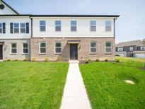 Inviting two-story townhouse featuring a brick facade, bright white siding, and a well-manicured lawn at 6192 Cascades Dr, Whitestown, IN 46075