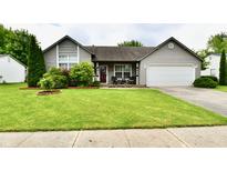 Charming single-story home with manicured lawn, covered porch, and attached two-car garage at 73 Suncrest Dr, Greenwood, IN 46143
