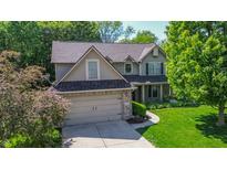 Beautiful two-story home featuring a two-car garage, well-manicured lawn, and lovely landscaping at 7322 Stones River Dr, Indianapolis, IN 46259