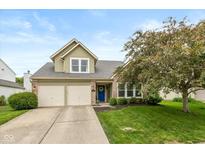 Charming two-story home with a blue front door, two-car garage, and landscaped front yard at 8958 Wooster Ct, Fishers, IN 46038
