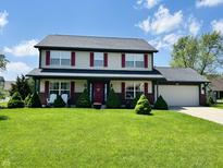 Charming two-story home with a well-manicured lawn, red door, and red shutters at 932 Eagle Brook Cir, Shelbyville, IN 46176