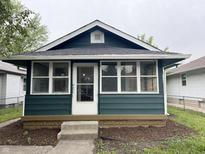 Charming home with a dark green exterior and a sunny, glass enclosed, front porch at 946 N Somerset Ave, Indianapolis, IN 46222