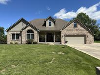 Charming brick home with a well-manicured lawn, beautiful landscaping, and an attached two-car garage at 10 Sara Ct, Whiteland, IN 46184