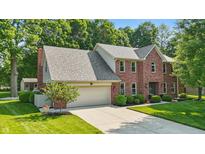 Charming two-story brick home with an attached two-car garage and a well-manicured lawn at 10418 Forest Creek Dr, Indianapolis, IN 46239