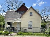 Charming two-story home featuring a welcoming porch and a well-maintained, fenced yard under a bright blue sky at 1164 Groff Ave, Indianapolis, IN 46222