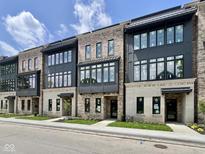 Modern townhome exterior featuring a brick facade, black framed windows, and covered entryways at 120 First Ne Ave, Carmel, IN 46032