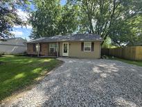 Charming single-story home with gravel drive, manicured lawn and mature trees offering shade at 1263 Barefoot Trl, Greenwood, IN 46142