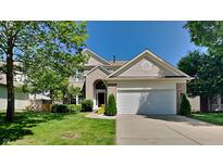 Charming two-story home with a well-manicured lawn and attached two-car garage, complemented by mature trees at 12878 Ari Ln, Fishers, IN 46037