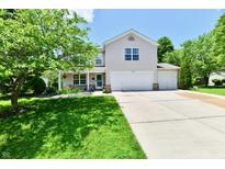 Inviting two-story home with a well-manicured lawn, charming landscaping, and a three-car garage at 16857 Palmetto Way, Noblesville, IN 46062