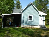 Charming home exterior with blue siding, white trim, carport, and well-maintained lawn at 2007 Park Ave, Anderson, IN 46016