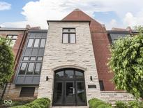 Stunning building entrance featuring stone facade, black framed doors, and well-maintained landscaping at 222 N East St # 103, Indianapolis, IN 46204