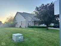 Charming single-Gathering home featuring a well-manicured lawn, brick facade, and mature tree at 3037 Ash Way, Lapel, IN 46051